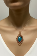 Azure Ember Talisman pendant worn on a model, featuring handwoven copper artistry and a vibrant blue cabochon stone.