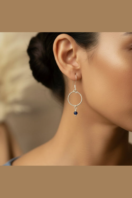 Model wearing Blue Haven handmade blue chalcedony earrings crafted with silver-toned copper in a minimalist circle design.
