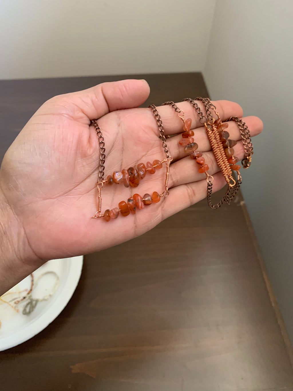 Close-up of Canyon Glow handmade necklace showing natural orange Carnelian gemstone chips, copper wire wrapping, and antique copper-toned chain.