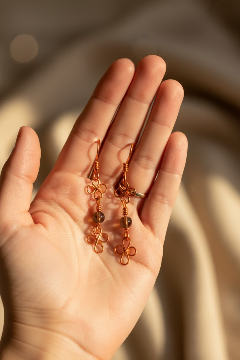 Pair of clover-whisper-earrings copper wire earrings on a hand