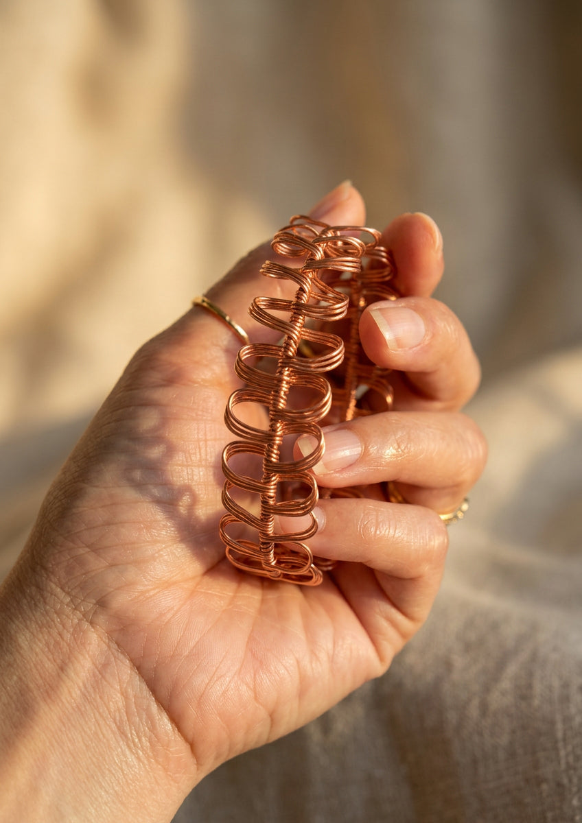 Close-up of the handcrafted Copper Rhapsody copper wire bracelet featuring sculptural repeating loops.