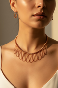 Woman wearing the handmade Copper Sonata woven copper choker with matching artisan copper earrings featuring elegant layered chain drapes.