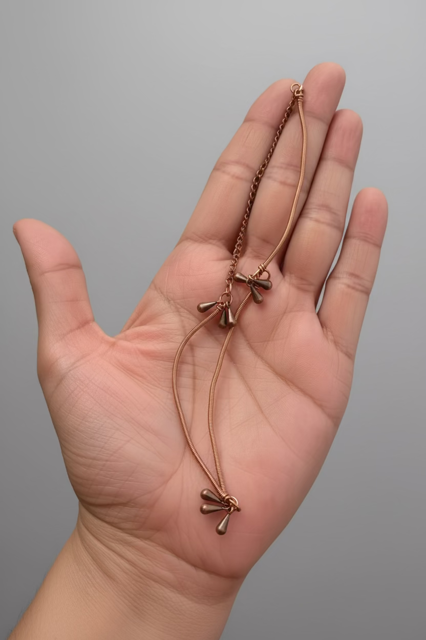 Hand holding the Dewdrop Dance handcrafted adjustable copper anklet.