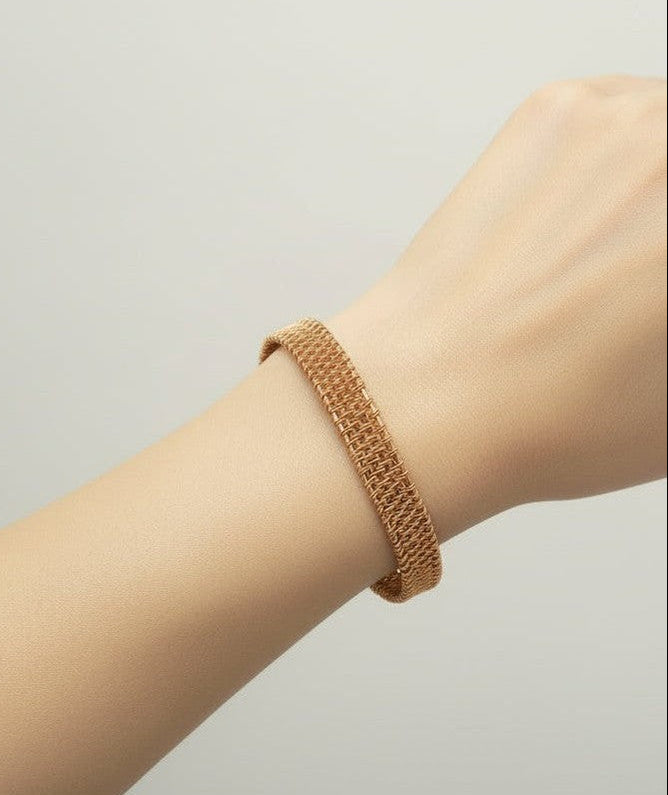 Emberloom handcrafted copper wire woven bracelet worn on the wrist, highlighting its elegant open cuff design and intricate woven texture.