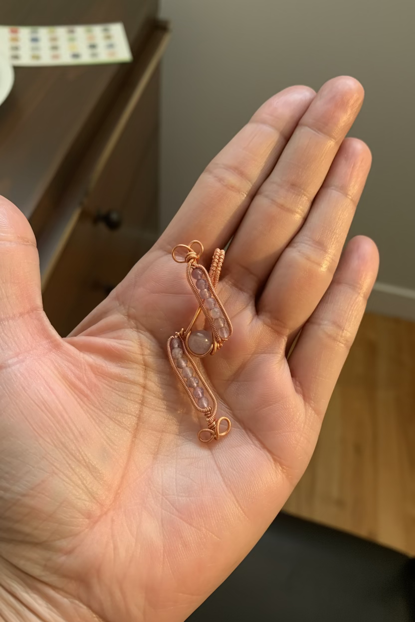 Close-up of the handcrafted Evening Lilac pendant resting in hand, featuring fourteen genuine amethyst beads and a violet center bead wrapped in warm copper wire.