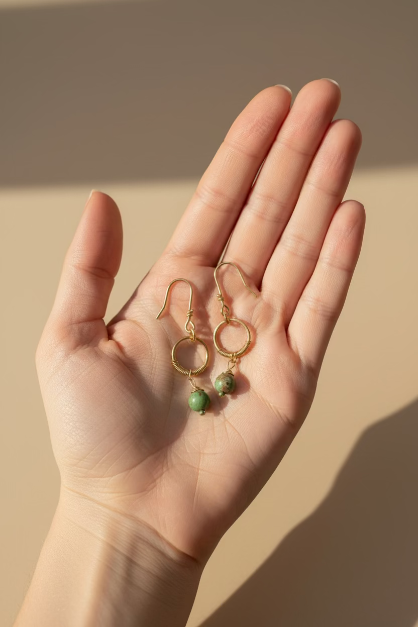 Hand holding the Evergreen Grace unakite and copper earrings, highlighting the handcrafted copper wirework and natural gemstone beads.