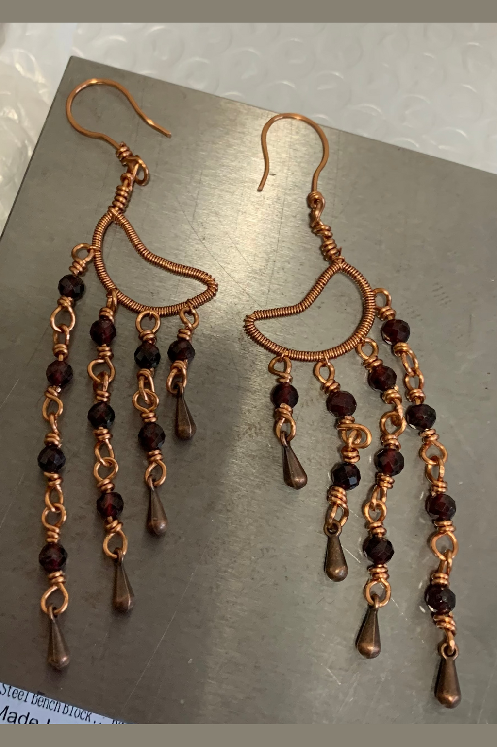 Pair of handcrafted Garnet Alchemy Cascade Earrings with red garnet beads, intricate copper wire wrapping, and dangling copper teardrops.