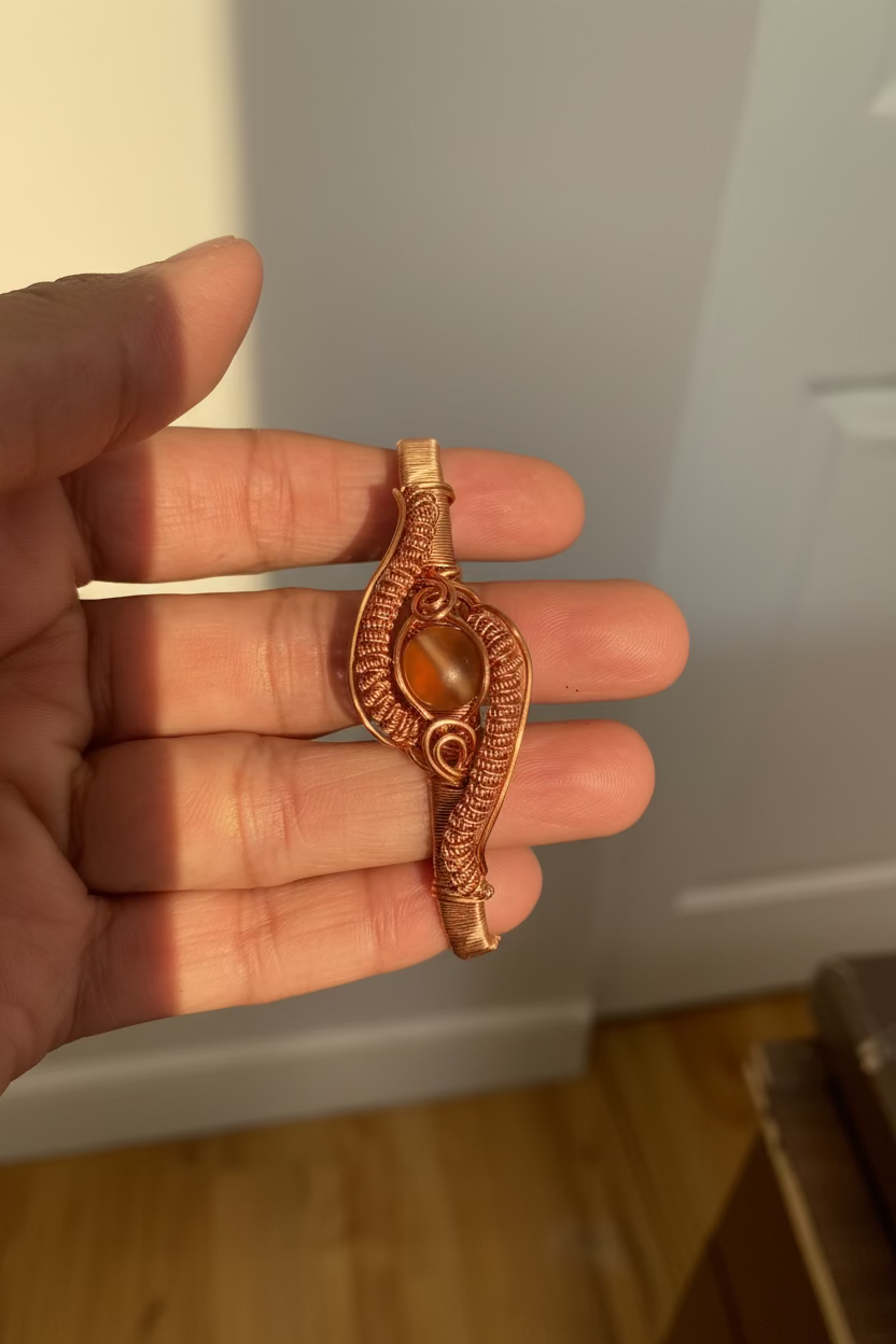 Handmade copper wire wrapped cuff bracelet featuring a mystic aura quartz with intricate woven artisan details.