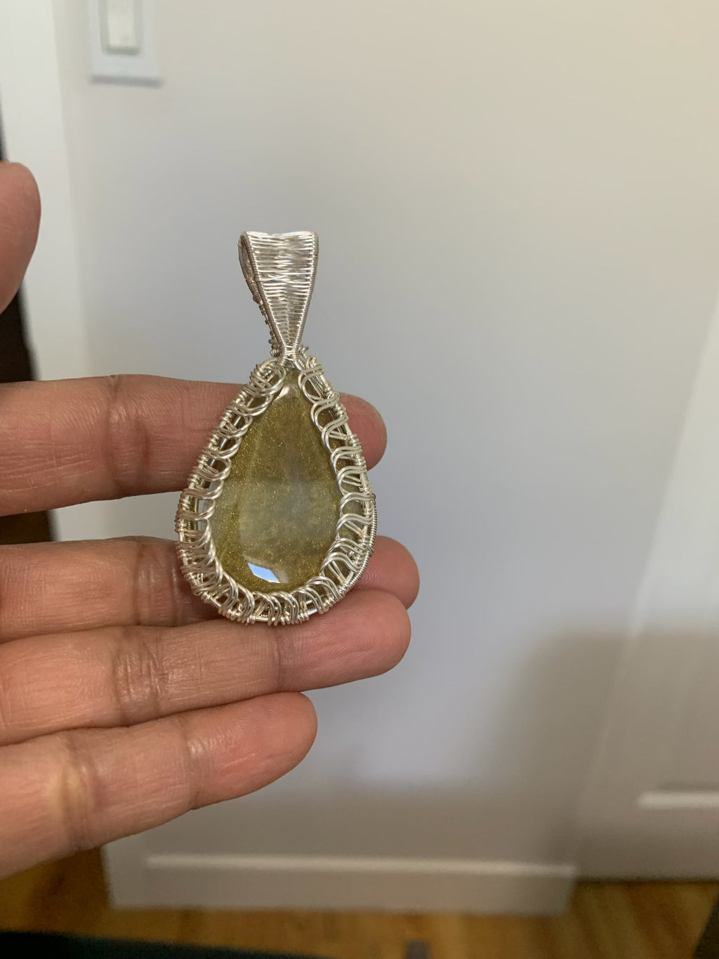 Golden Serenity Pendant featuring a handcrafted golden resin centerpiece wrapped in silver-toned wire.