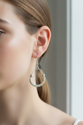 Model wearing Halo Grace Earrings handcrafted from silver-toned copper wire with delicate wrapped detailing.