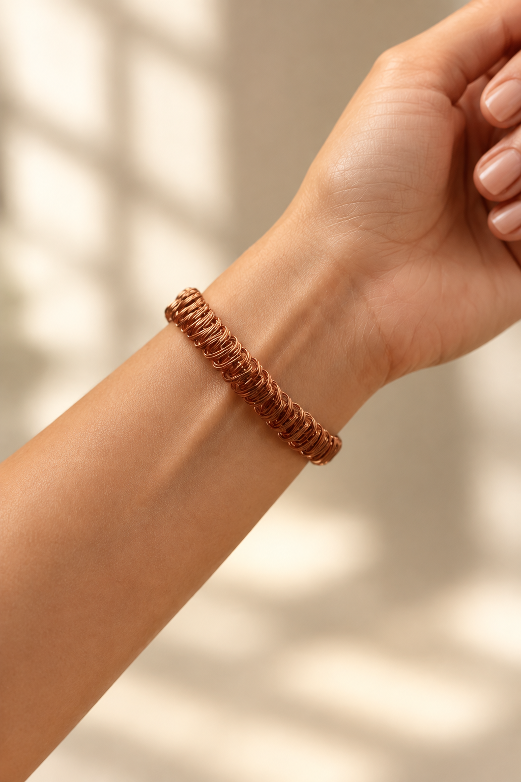 Handwoven copper bracelet worn on wrist showing detailed wire weave