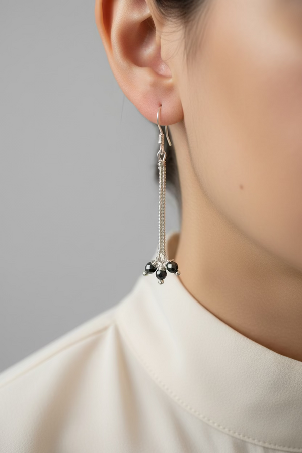 Model wearing handcrafted Hematite Stardust Earrings with faceted hematite and silver-toned copper wire, showcasing their elegant 2.5-inch drop and graceful movement.