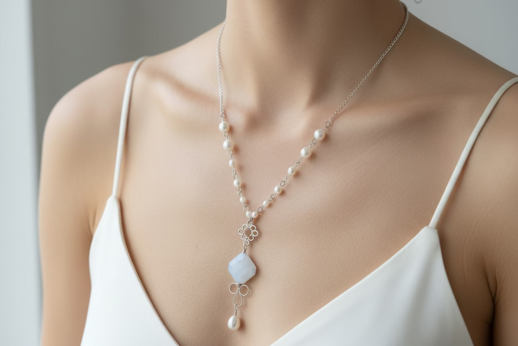 Handcrafted silver-toned copper necklace with white pearl beads and a white center bead, worn on a model with a delicate pearl drop pendant.