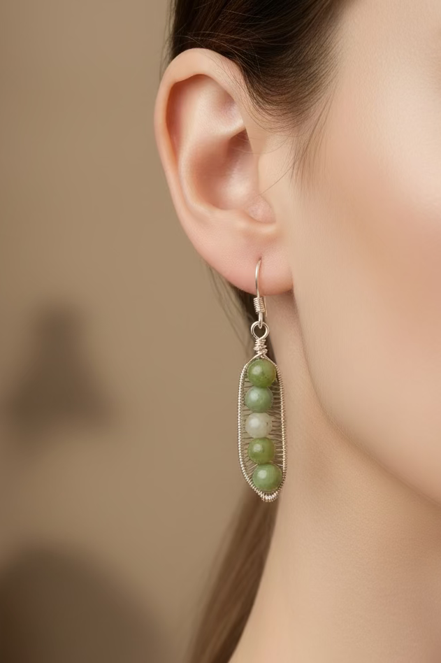 Model wearing handmade Green China Jade Peapod earrings in silver-toned copper wire.