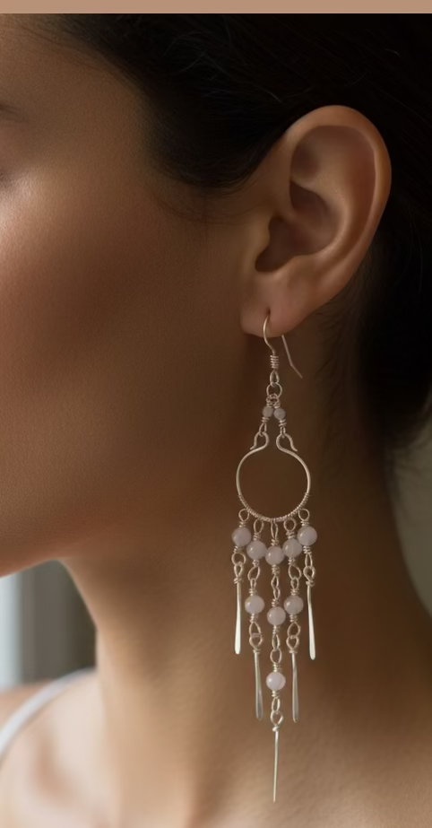 Woman wearing handcrafted Moonstone Rain chandelier earrings featuring natural moonstone beads and silver-toned copper wire with cascading chain details.