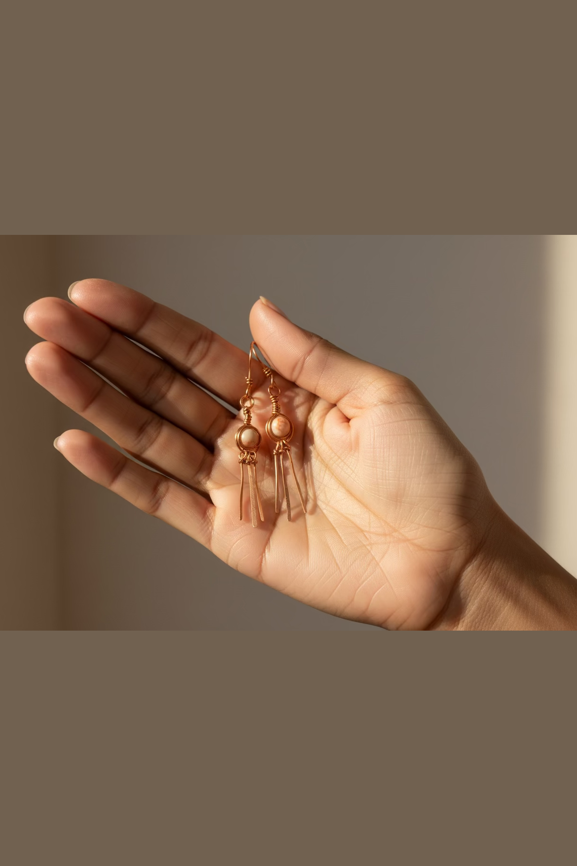 Handmade red line jasper earrings in copper wire wrap, close-up detail of natural stone jewelry