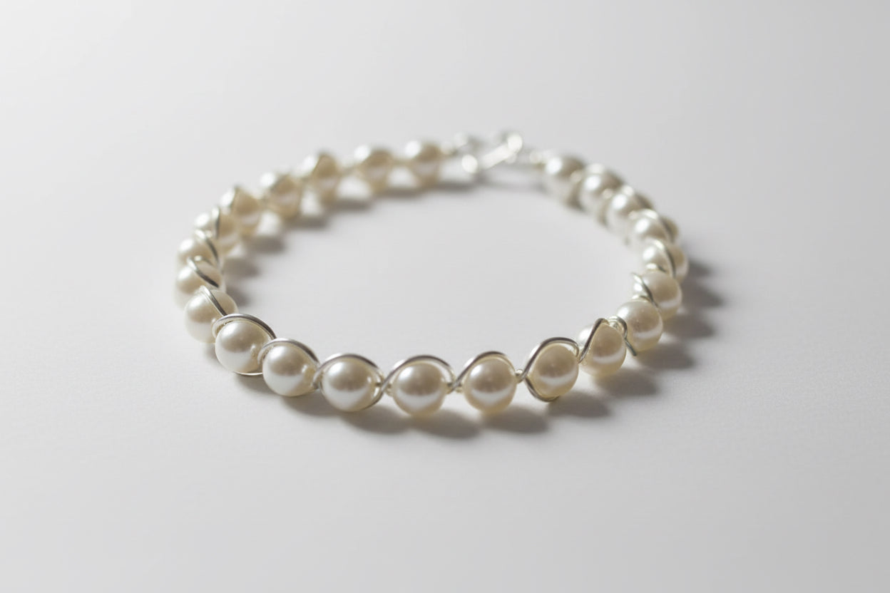 Pearl bracelet on a white surface with a dark background