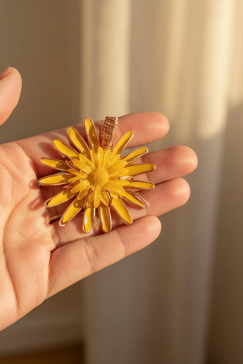 Yellow flower-shaped pendant held in a hand